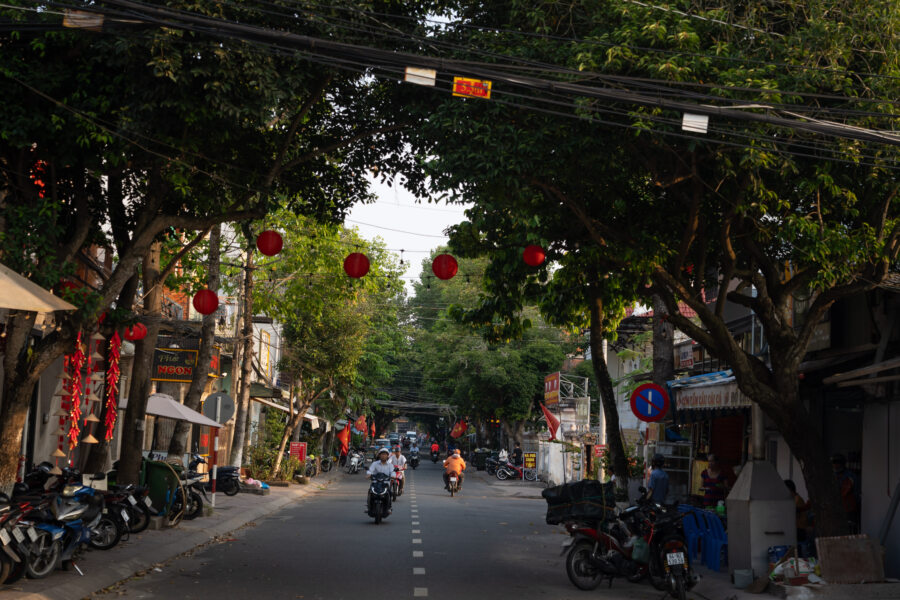 Rue avec arbres et scooters à Vinh Long au Vietnam